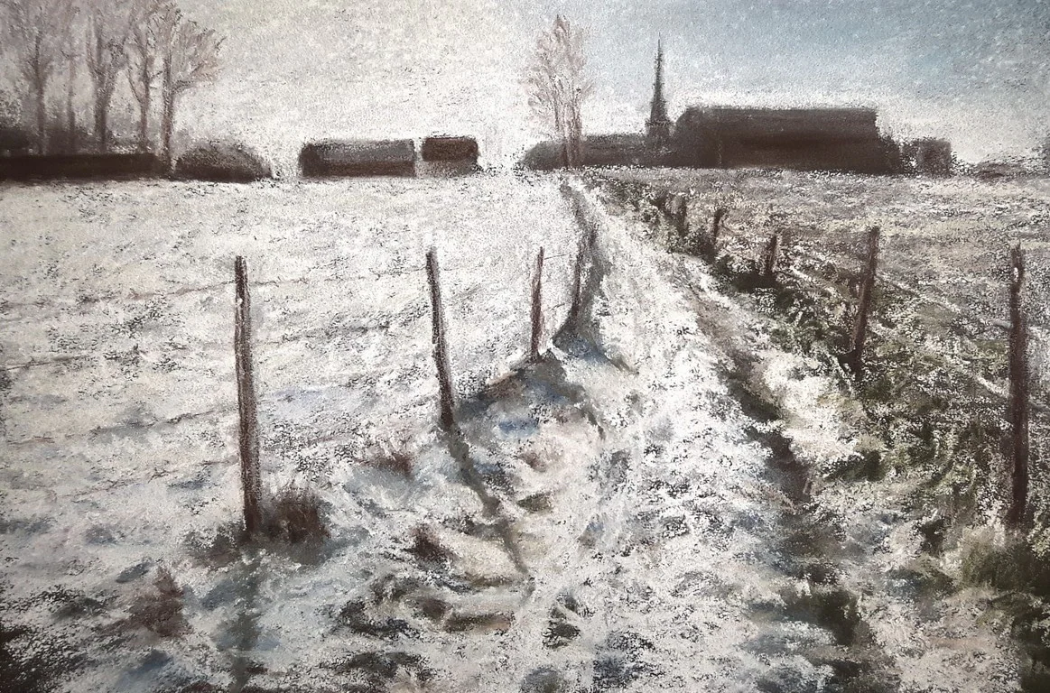 Un chemin bordé de piquets dans la campagne enneigée.