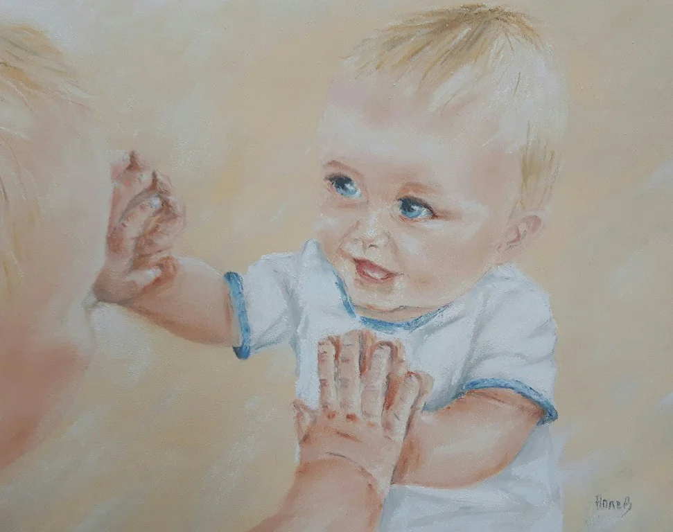Un tout-petit qui tend les mains vers son reflet.