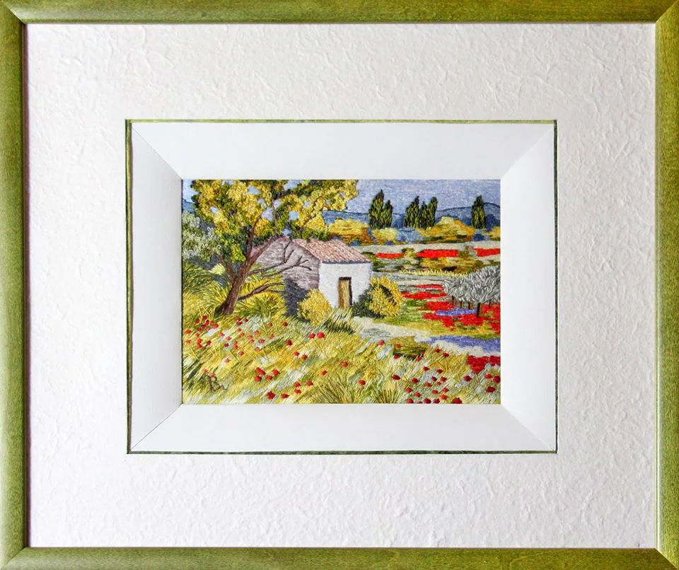 Paysage fleuri brodé, dans un cadre doré.