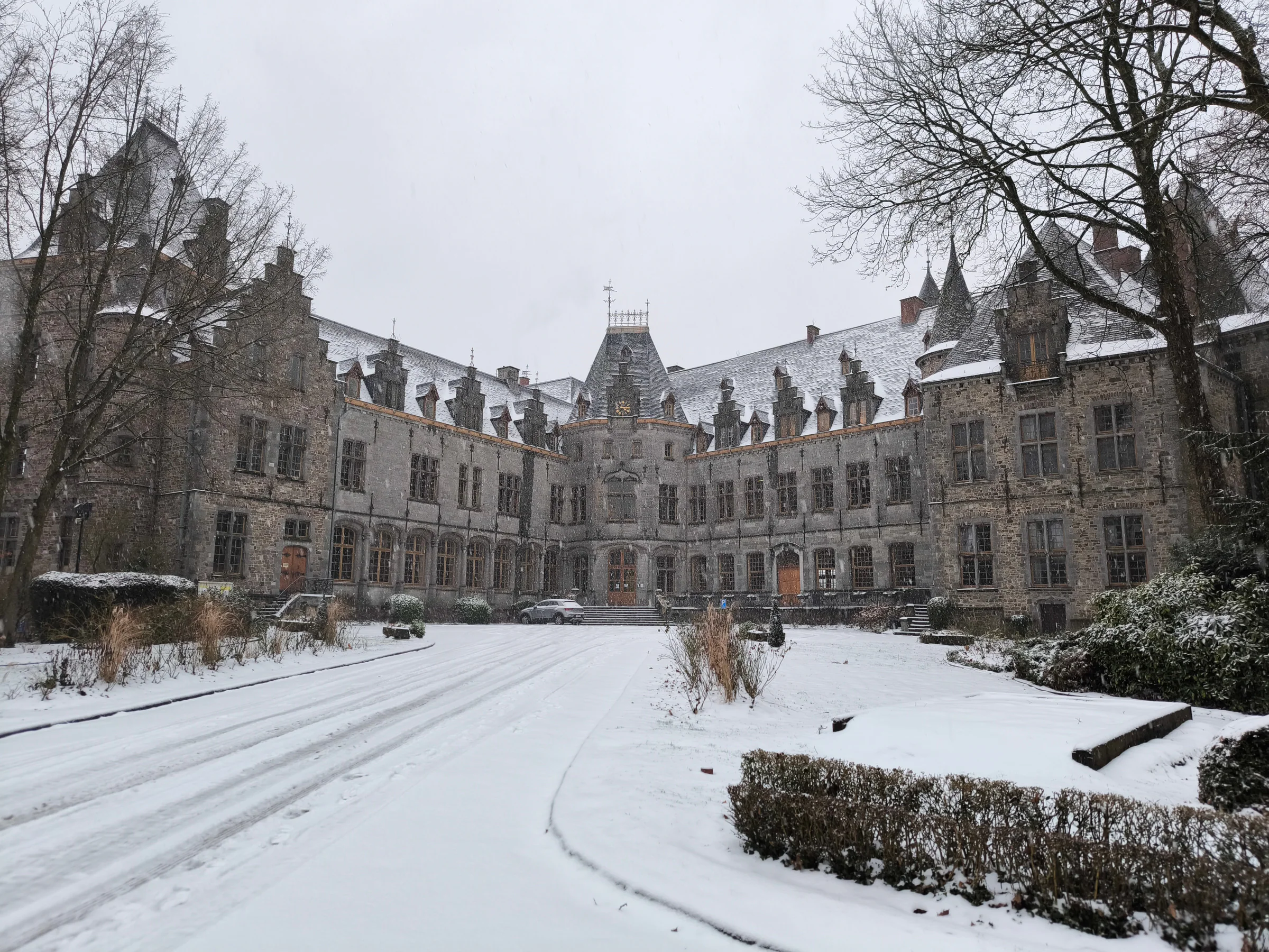 Le château sous la neige, ses toits blancs au-dessus du parc.