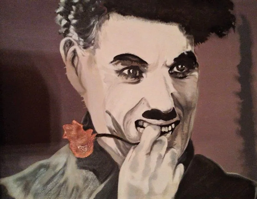 Portrait de Charlie Chaplin, une fleur à la main.