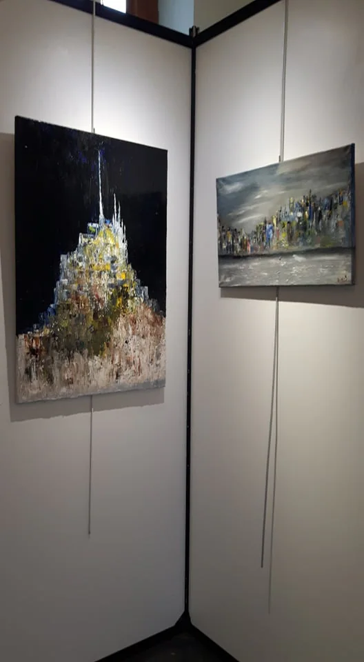 Toiles accrochées sur des panneaux d'exposition.