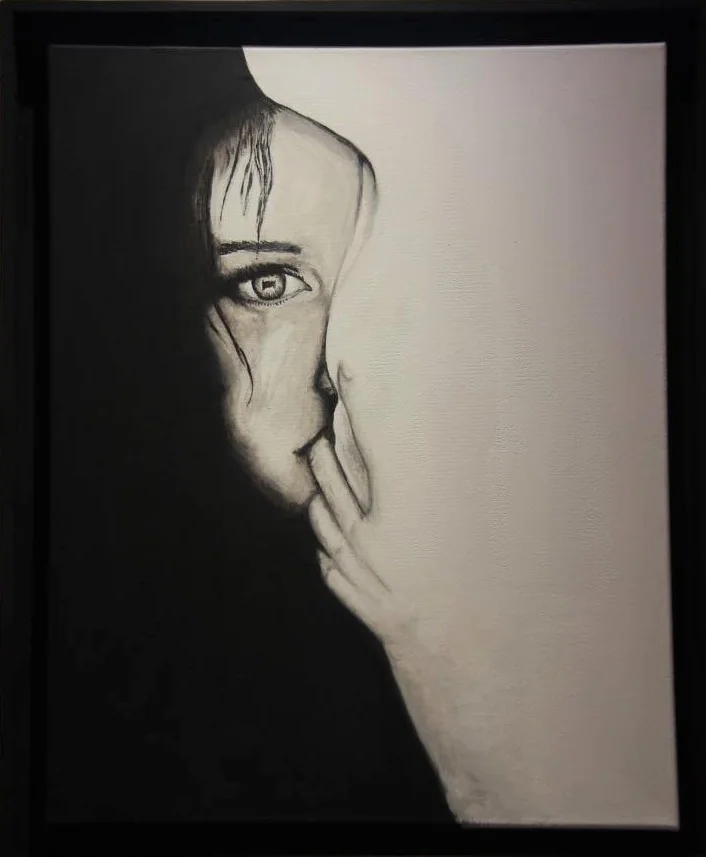 Un visage de femme à demi caché par sa main, en noir et blanc.