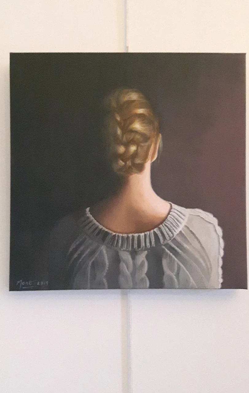 Une femme vue de dos, les cheveux tressés.