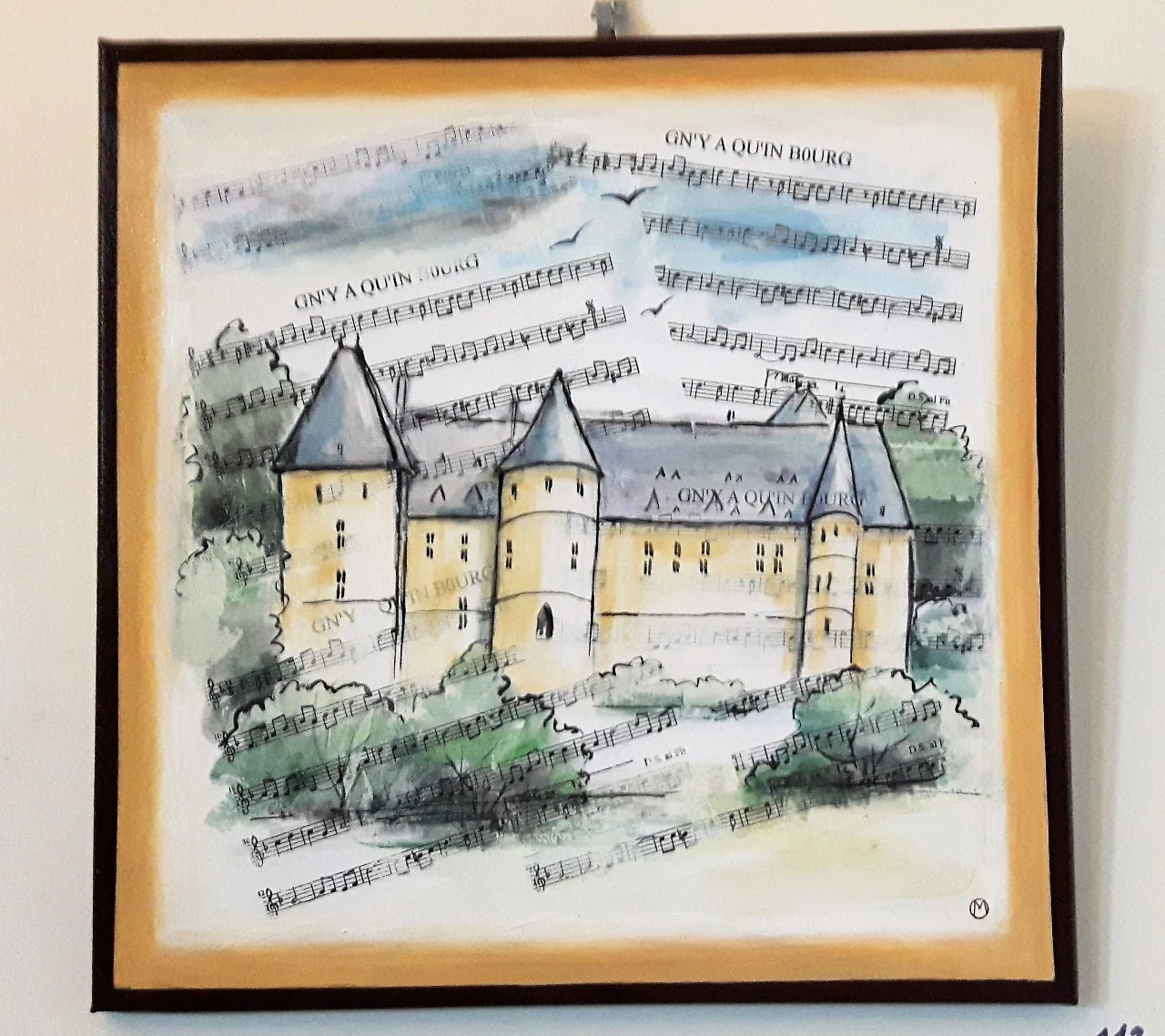 Aquarelle d'un château à tours rondes, peinte sur une partition, dans un cadre noir.