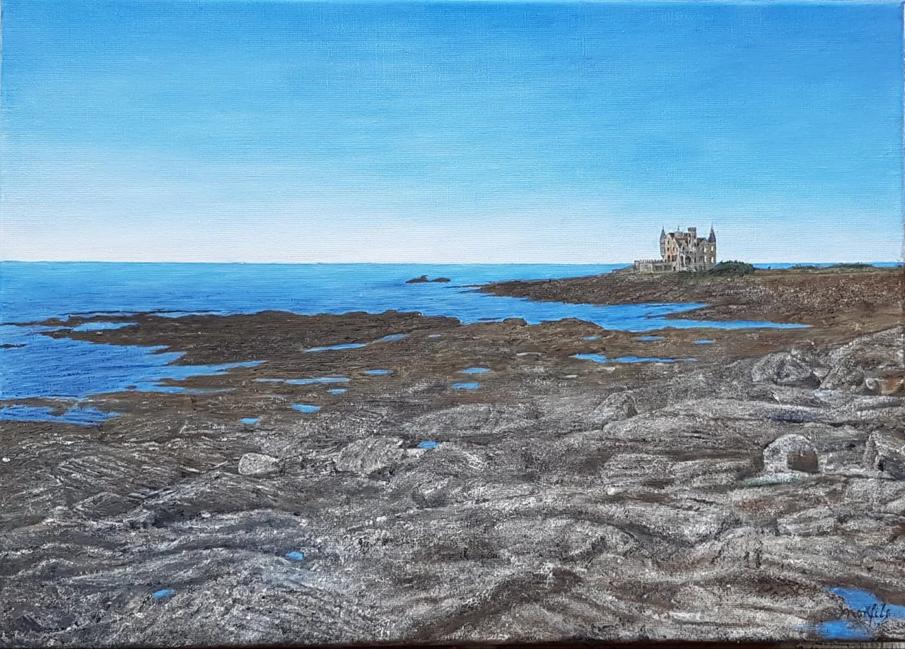Une côte rocheuse sous un ciel bleu, un château au loin.