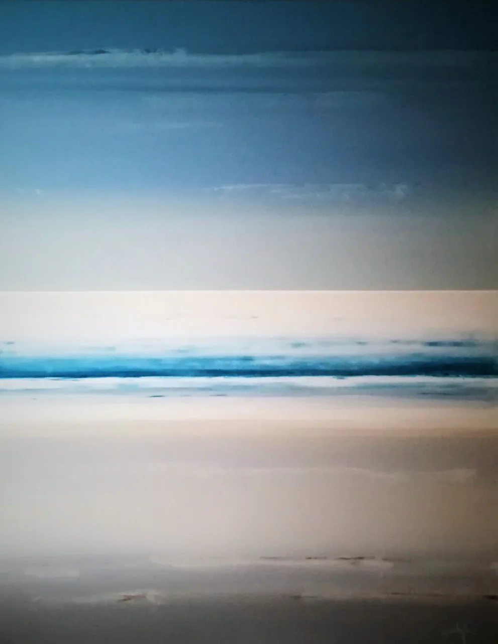 Une mer bleue sous un ciel blanc.