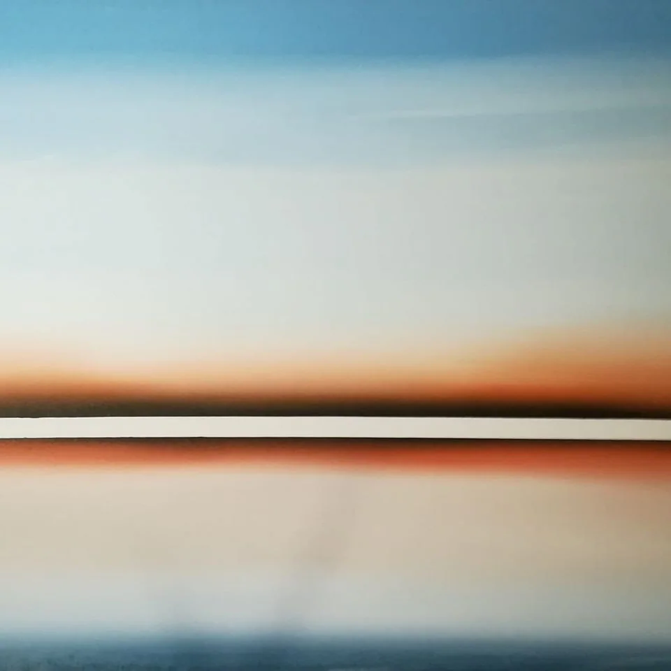 Un ciel bleu pâle traversé d'une ligne orangée.