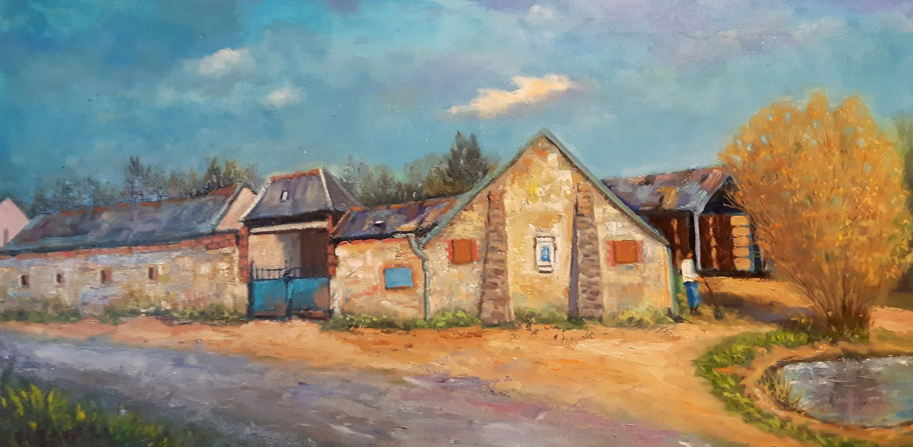 Une ferme et son étang au bord d'un chemin de campagne, en format panoramique.