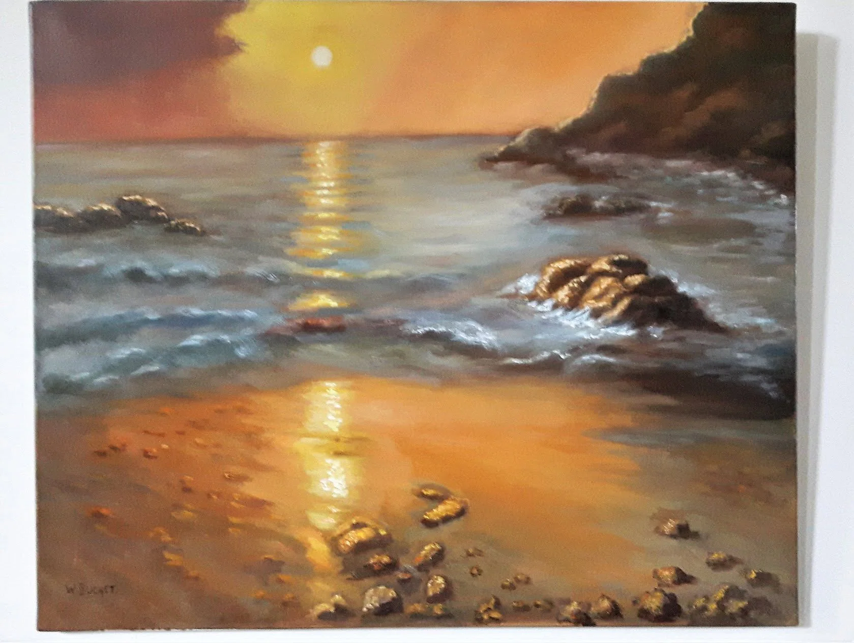 Le soleil se couche sur la mer et les rochers.